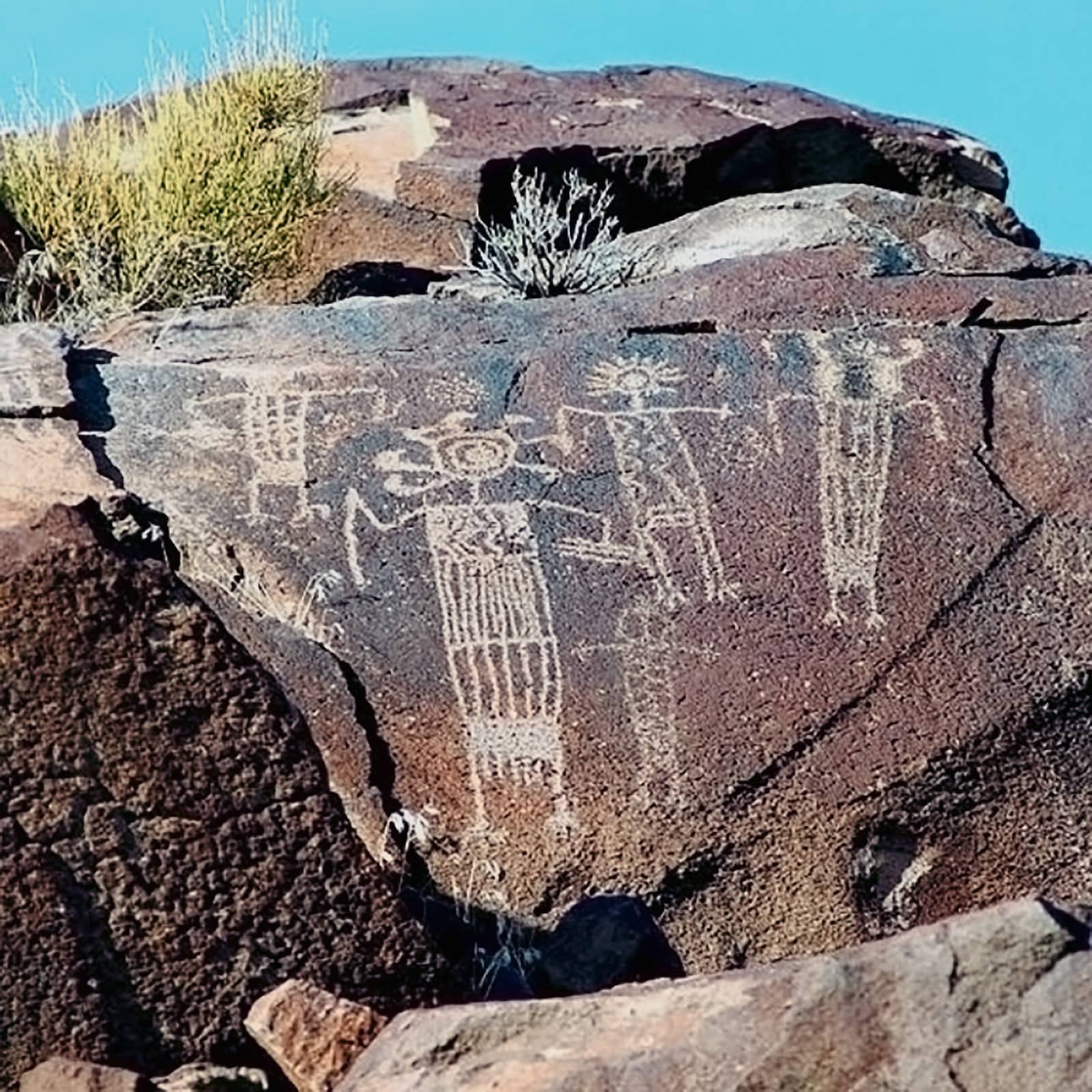 Master/mistress of the game animals protects the animal and offers or withholds them from the hunters. Note the objects being held by the large central figure. The long slender rod is most likely an atlatl spear thrower