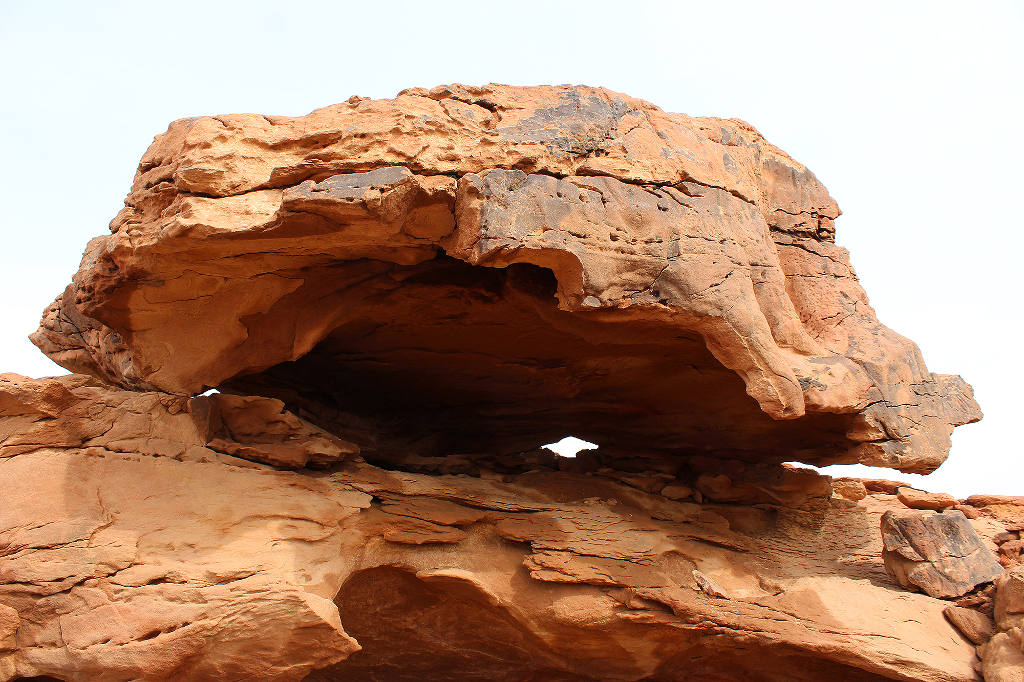 Case hardening has preserved the varnished outer shell with the relief, hollowing out of the softer rock is gradually causing its collapse