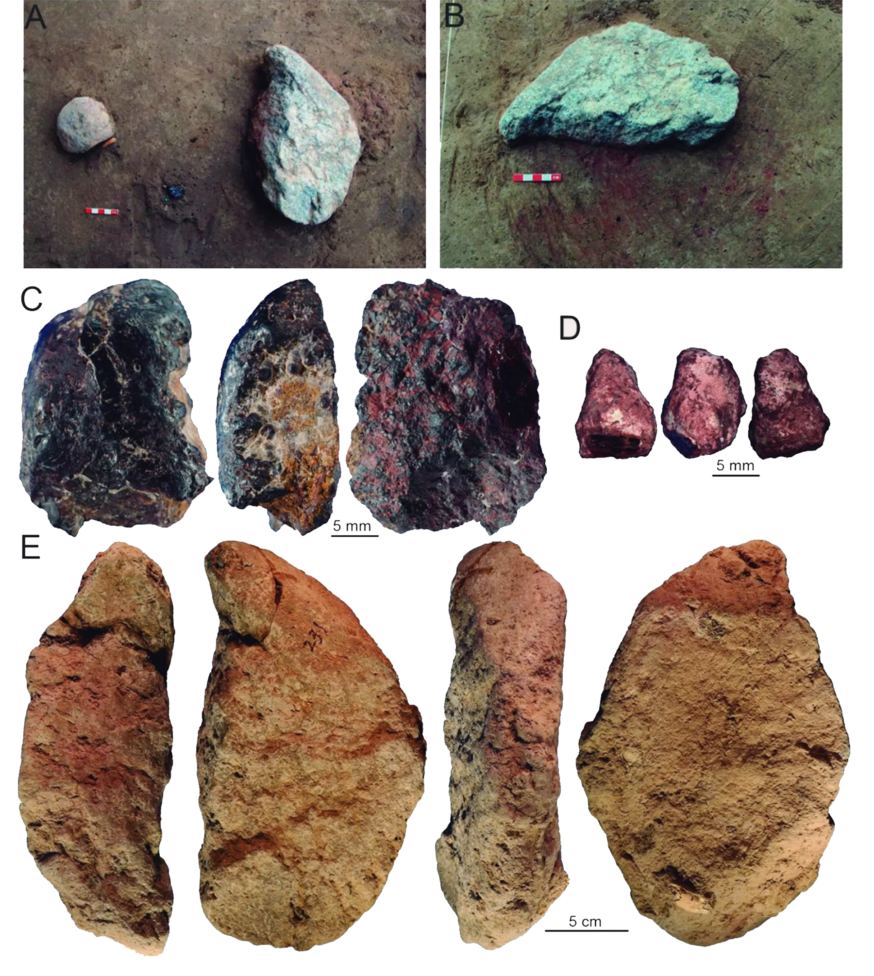 Pieces of ocher and stone-working implements lying on a red-colored pigment spot
