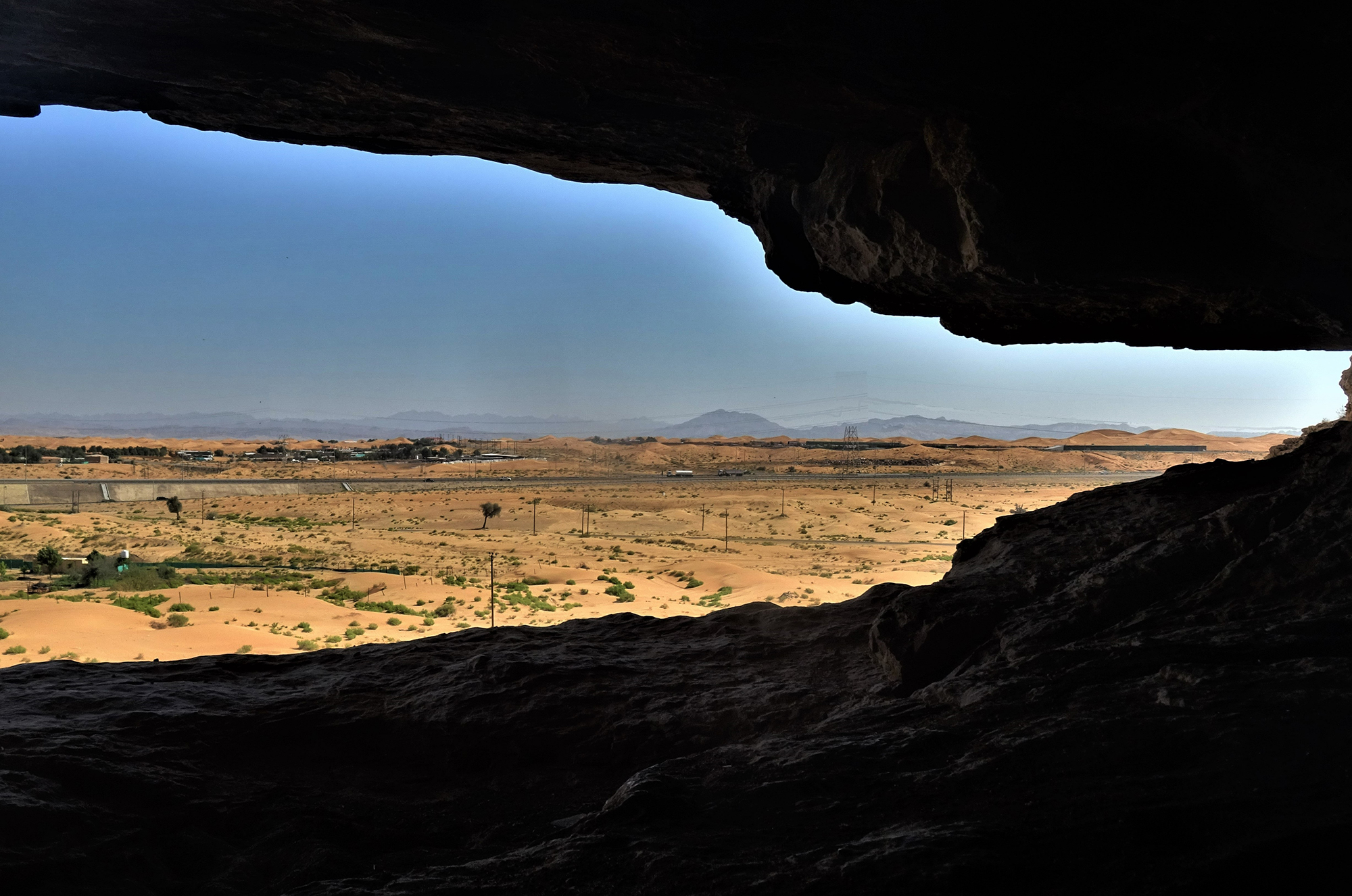 The cliff-face and rock shelter within the central enclave on the western flank of Qarn bint Sa’ud and views across the arid landscapes