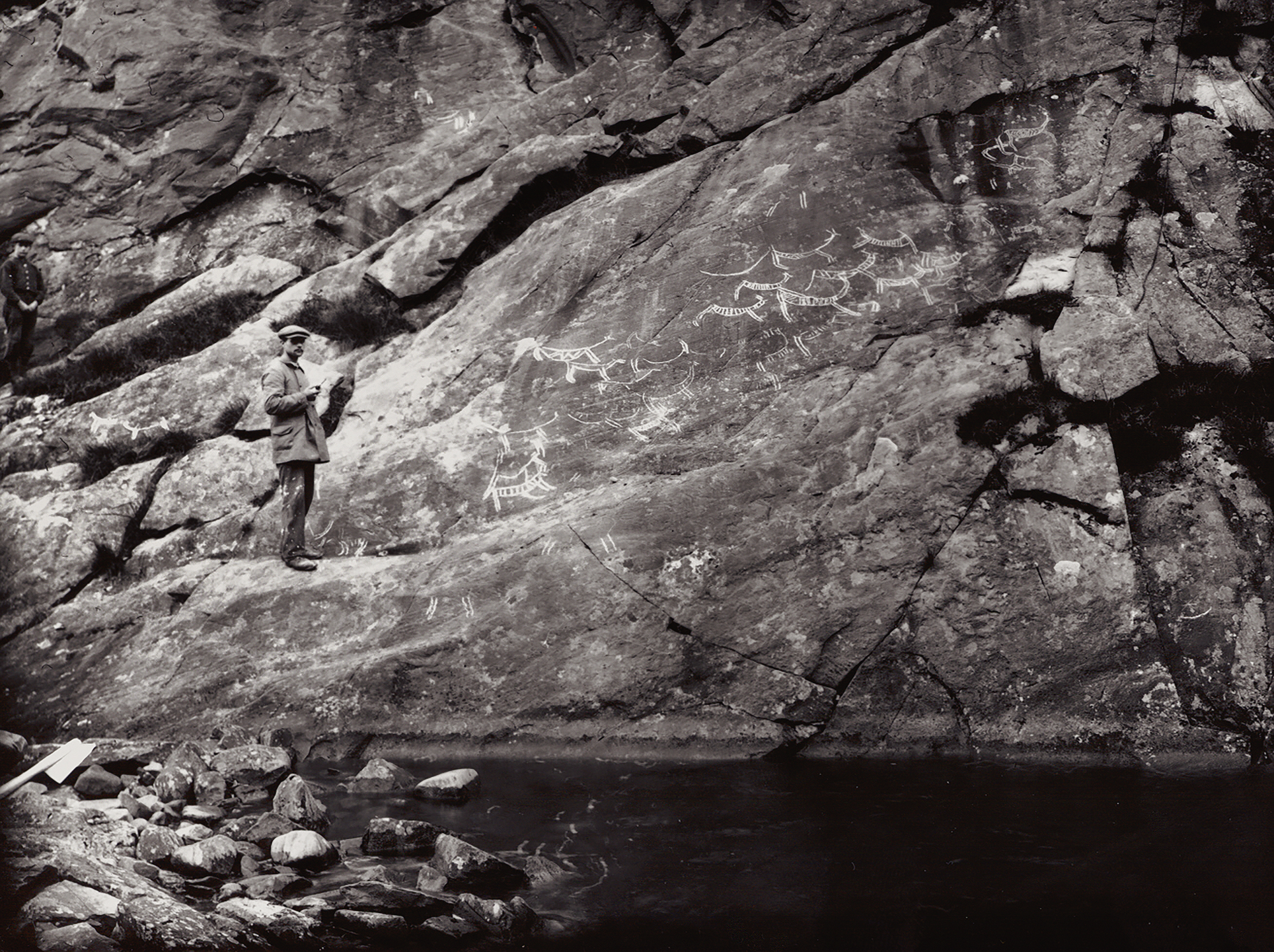 Documentation work in 1913 Preparant Espevoll takes a pipe while waiting for the photographer Gustaf Hallström to finish Vingen Rock Art Carvings Norway